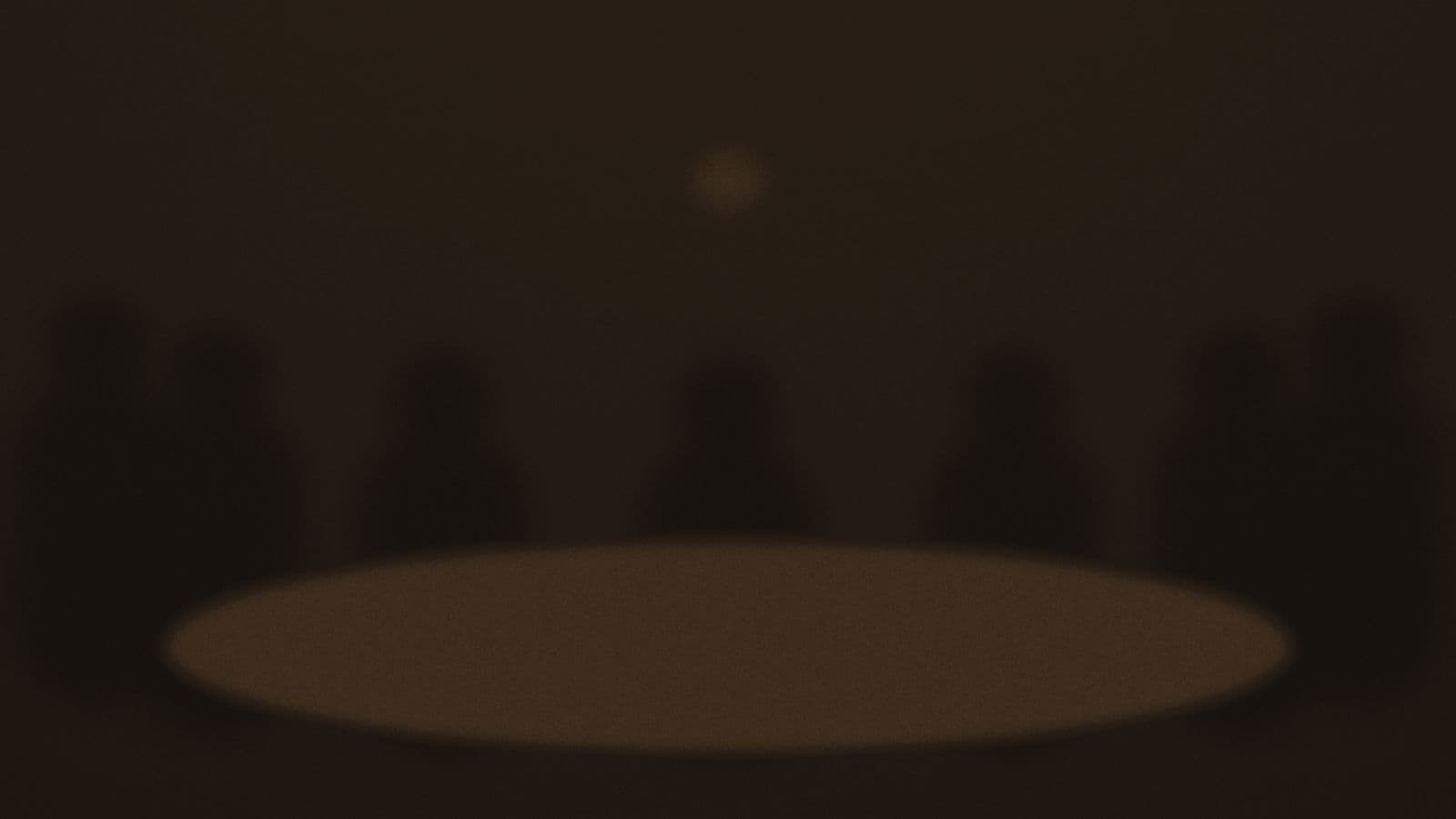 A round table under one low lamp, ringed by seated figures.