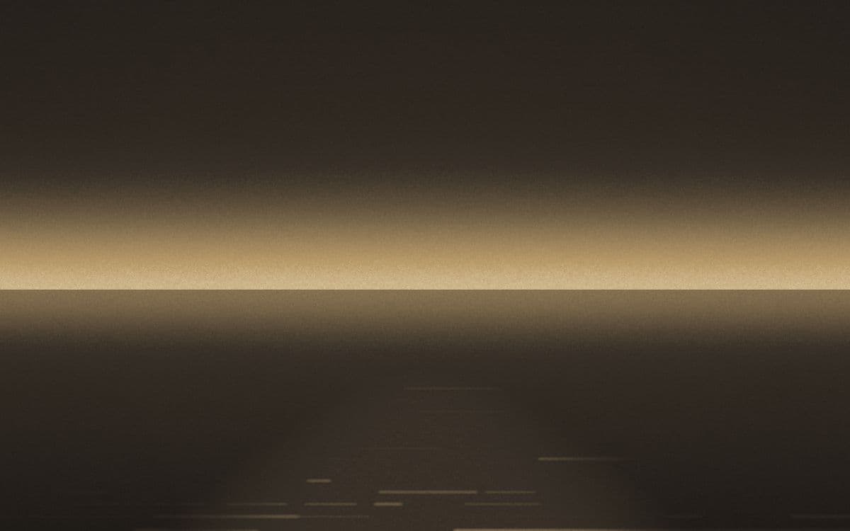 A low horizon at dusk with a path of light reflected across still water.