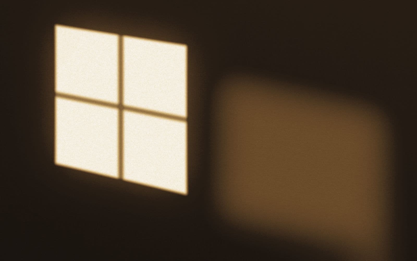 Late afternoon light falling through a paned window onto a plain interior wall.