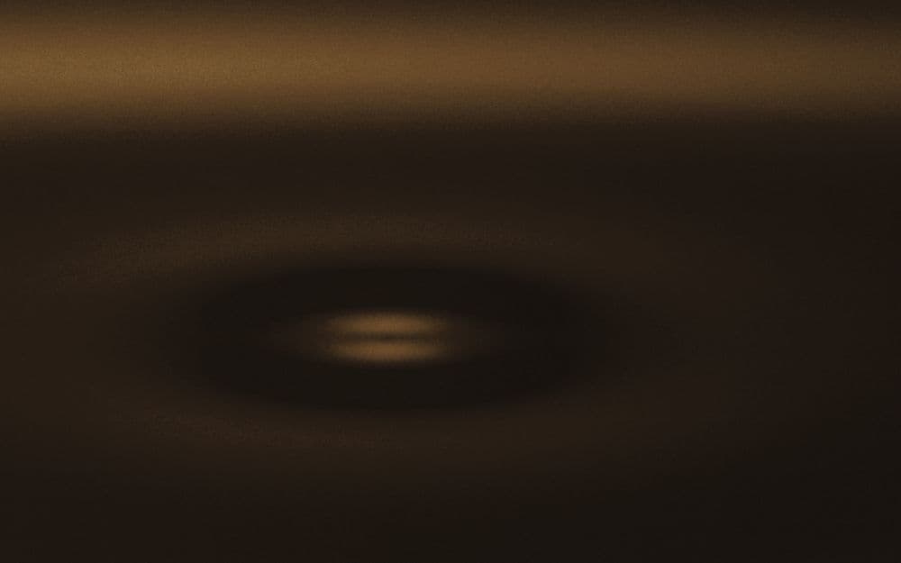 Concentric ripples spreading across dark water.