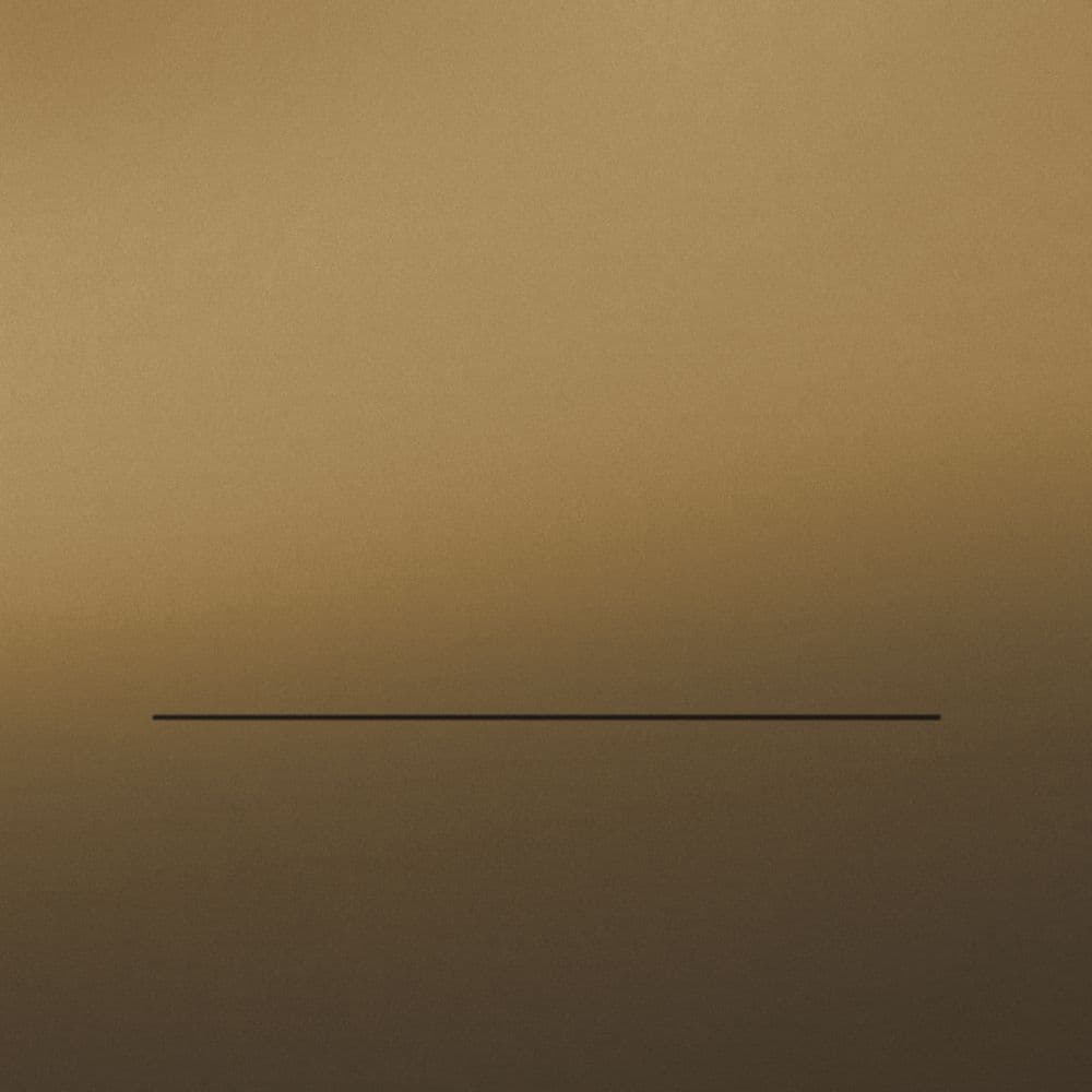 A warm sand-toned sleeve with a slow band of light and a single rule.