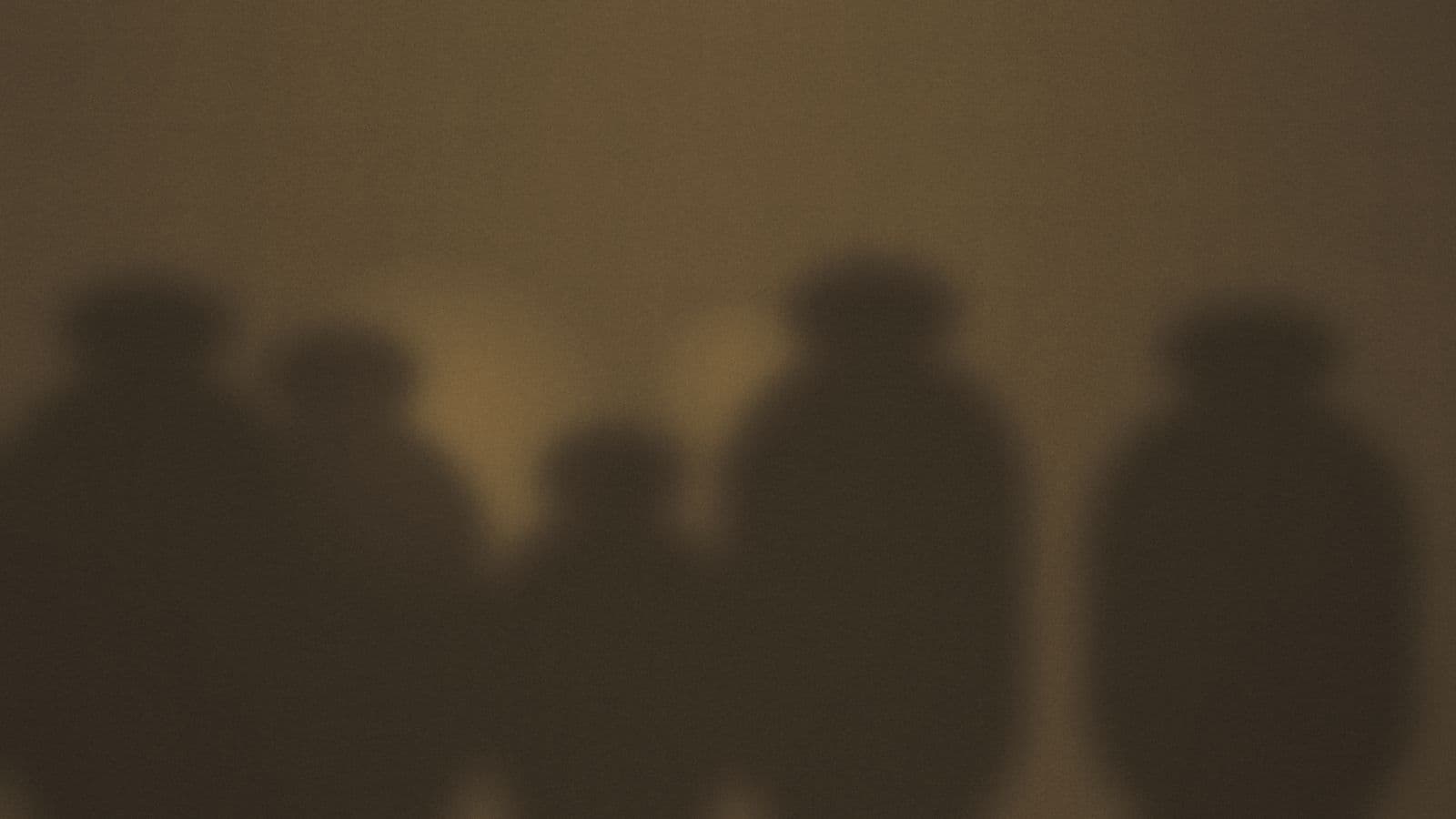 People gathered quietly around low warm light.