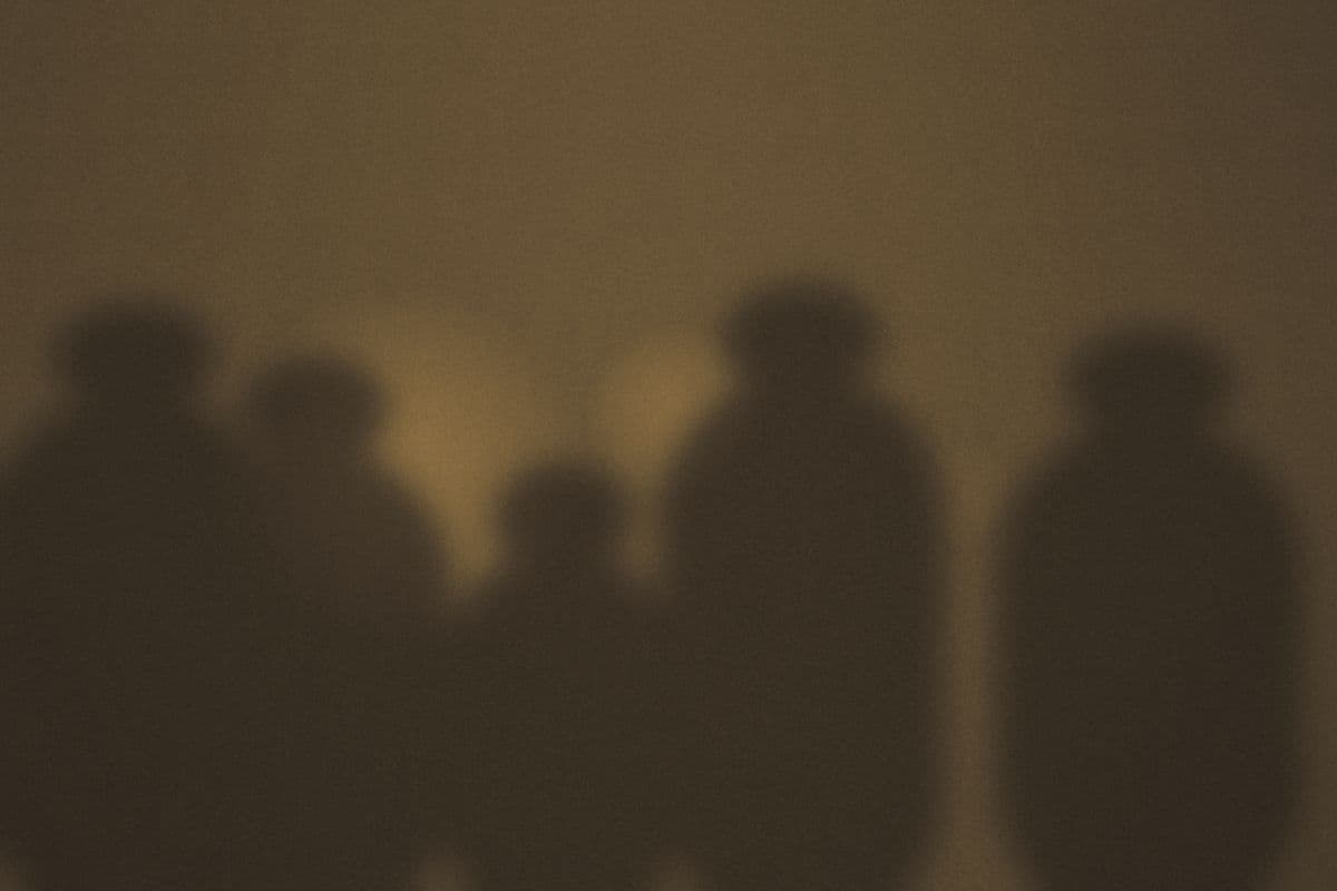 A handful of people gathered around low warm light.