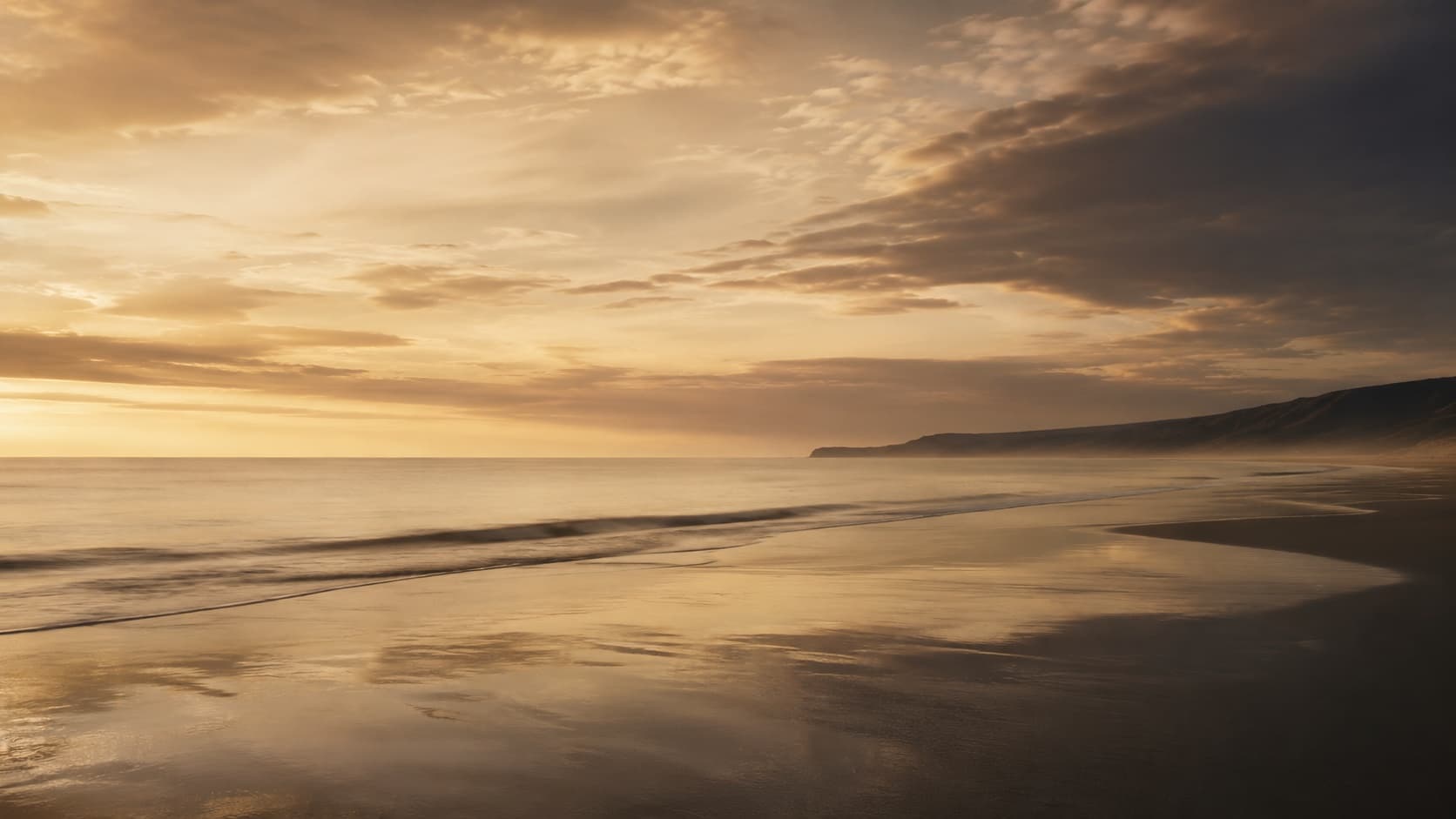 A low horizon at dusk with light broken across the water.